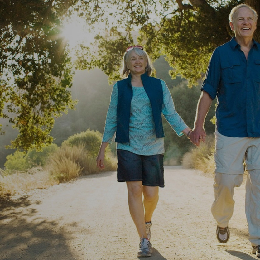 Older couple walking holding hands
